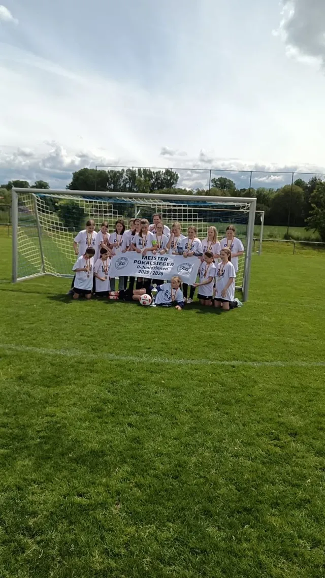 Die D-Juniorinnen der SG Obersasbach mit dem Meister- und Pokalsieger-Banner der Saison 2025/26